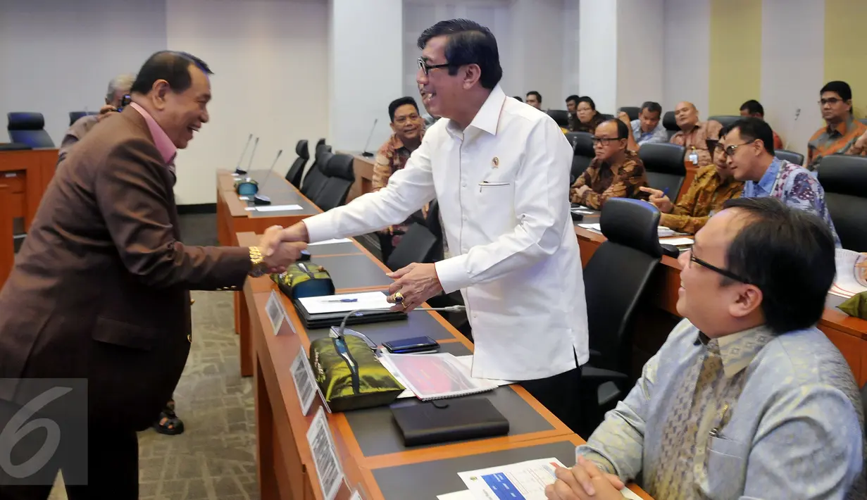 Menkumham Yasonna Laoly berjabat tangan dengan anggota Banggar DPR sebelum menggelar rapat kerja di kompleks Parlemen, Jakarta, Selasa (21/6). Rapat terkait pembahasan postur sementara RUU tentang perubahan APBN tahun 2016. (Liputan6.com/Johan Tallo)