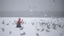 Seorang wanita mengabadikan burung camar dengan kameranya saat badai salju di pantai Coney Island, New York (10/3). NWS menetapkan status darurat untuk negara bagian New York dan New Jersey yang terancam dilanda badai salju. (AP Photo / Mary Altaffer)