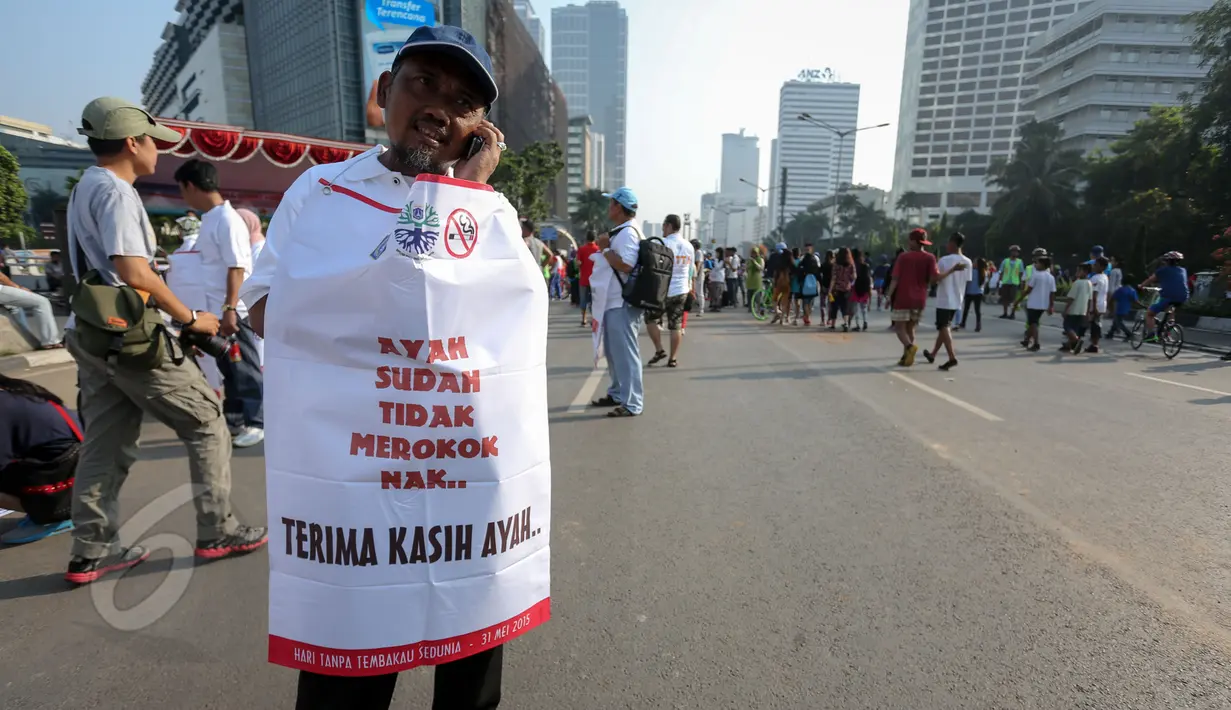 Aktivis mengenakan atribut bertuliskan "Ayah Sudah Tidak Merokok Nak" saat peringatan Hari Tanpa Tembakau di Bundaran HI, Jakarta, Minggu (31/5). Gerakan ini menyerukan para perokok agar tidak merokok selama 24 jam serentak. (Liputan6.com/Faizal Fanani)