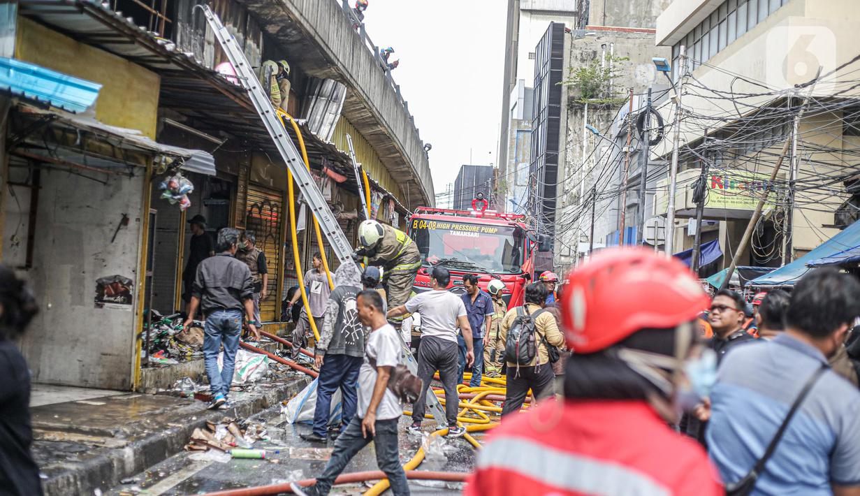 Petugas pemadam kebakaran saat melakukan proses pendinginan dari kebakaran di Pasar Pagi Asemka, Jakarta, Jumat (18/11/2022). Dugaan penyebab sementara, berdasarkan informasi awal dari lokasi terjadi korsleting listrik," sebut Joko. (Liputan6.com/Faizal Fanani)