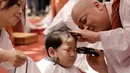 Ekspresi Seorang anak lelaki bernama Budha Myung Bub saat rambutnya dicukur oleh seorang biksu selama kebaktian merayakan ulang tahun ke-2.563 Buddha pada 12 Mei, di Kuil Jogye di Seoul, Korea Selatan, Senin (22/4). Sepuluh anak terpilih menjadi peserta peringatan ini. (AP Photo/Ahn Young-joon)