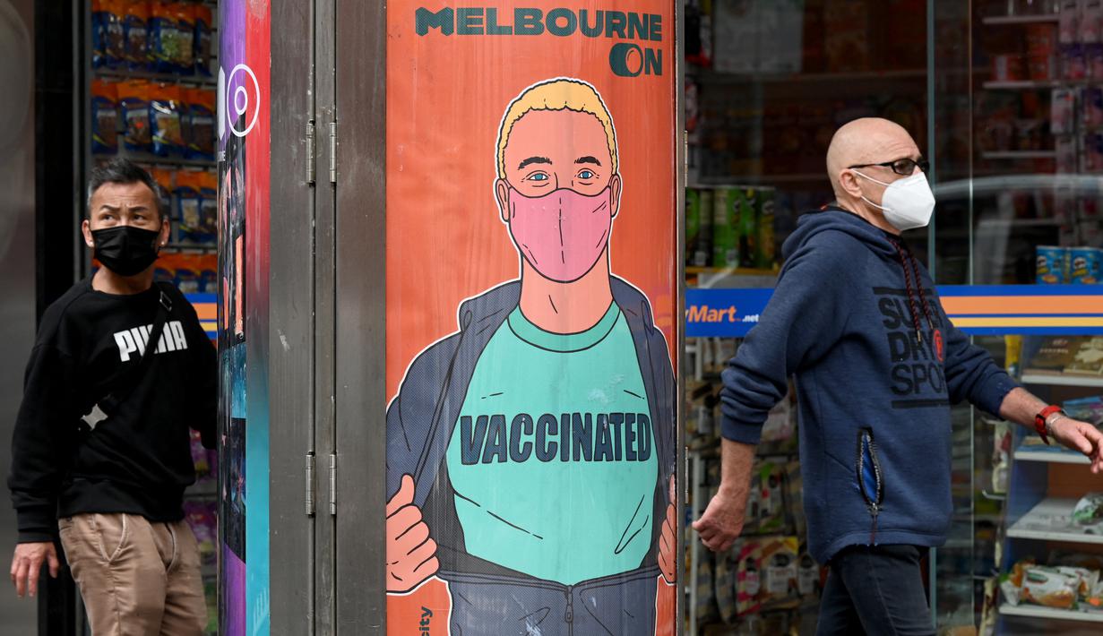 Orang-orang berjalan melewati poster yang mendorong vaksinasi di Melbourne, Australia, Kamis (30/9/2021). Melbourne bergulat dengan lonjakan infeksi Covid-19 di mana sebanyak 1.438 kasus dilaporkan, jumlah harian terbesar sejak awal pandemi. (William WEST / AFP)