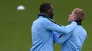 Pemain Manchester City, Yaya Toure bercanda dengan Kevin De Bruyne saat sesi latihan jelang laga Liga Champions di Manchester, Selasa (6/3/2018). Manchester City akan berhadapan dengan FC Basel. (AFP/ Oli Scarff)