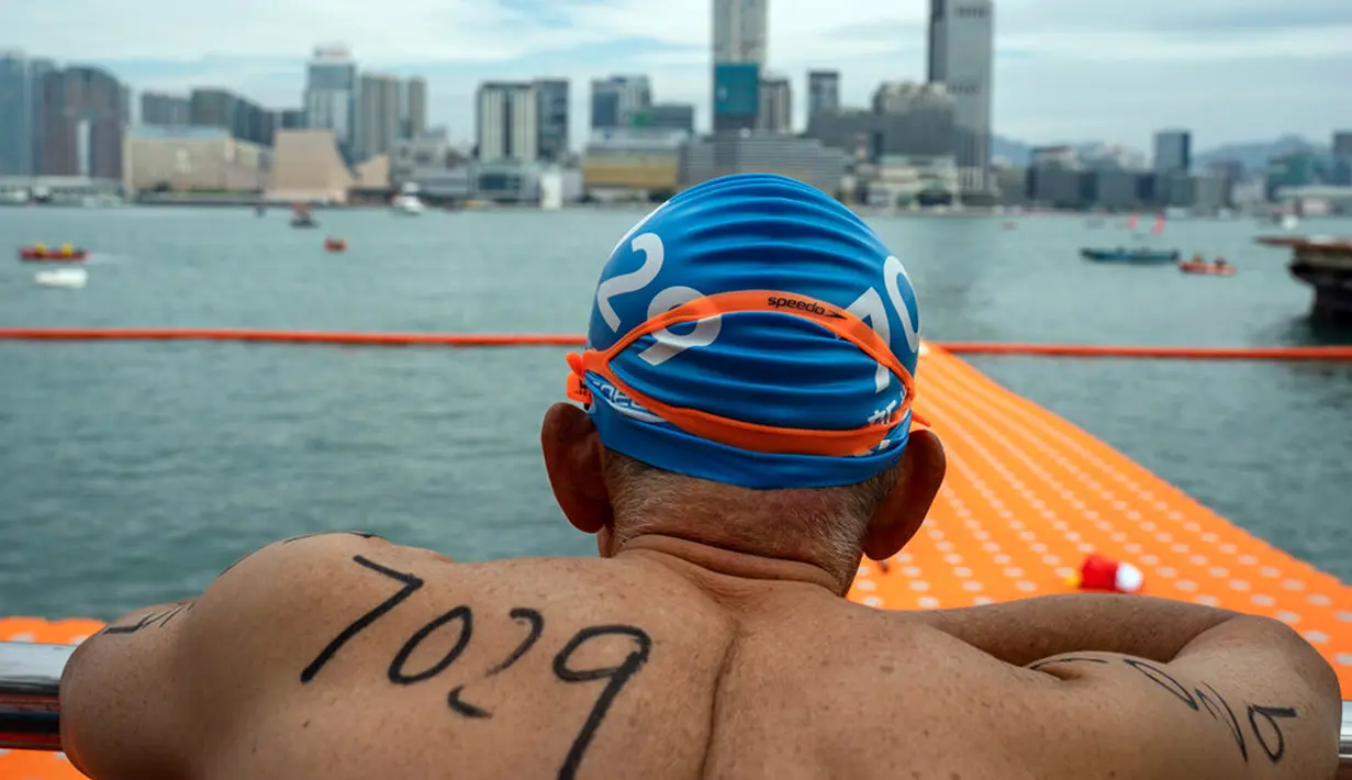Seorang perenang menunggu di garis start jelang lomba renang tahunan di Pelabuhan Victoria, Hong Kong, Minggu (23/10/2022). Acara tersebut merupakan perlombaan renang tahunan yang telah diadakan sejak 1906. (AP Photo/Anthony Kwan)