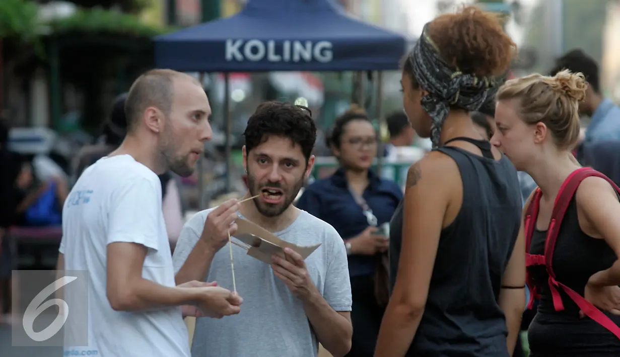 Wisatawan mancanegara menikmati sate ayam di Jalan Malioboro, Yogya, Kamis (4/8). Makanan cepat saji ini banyak dijual di sepanjang Jalan Malioboro dengan harga yang terjangkau. (Liputan6.com/Boy Harjanto)