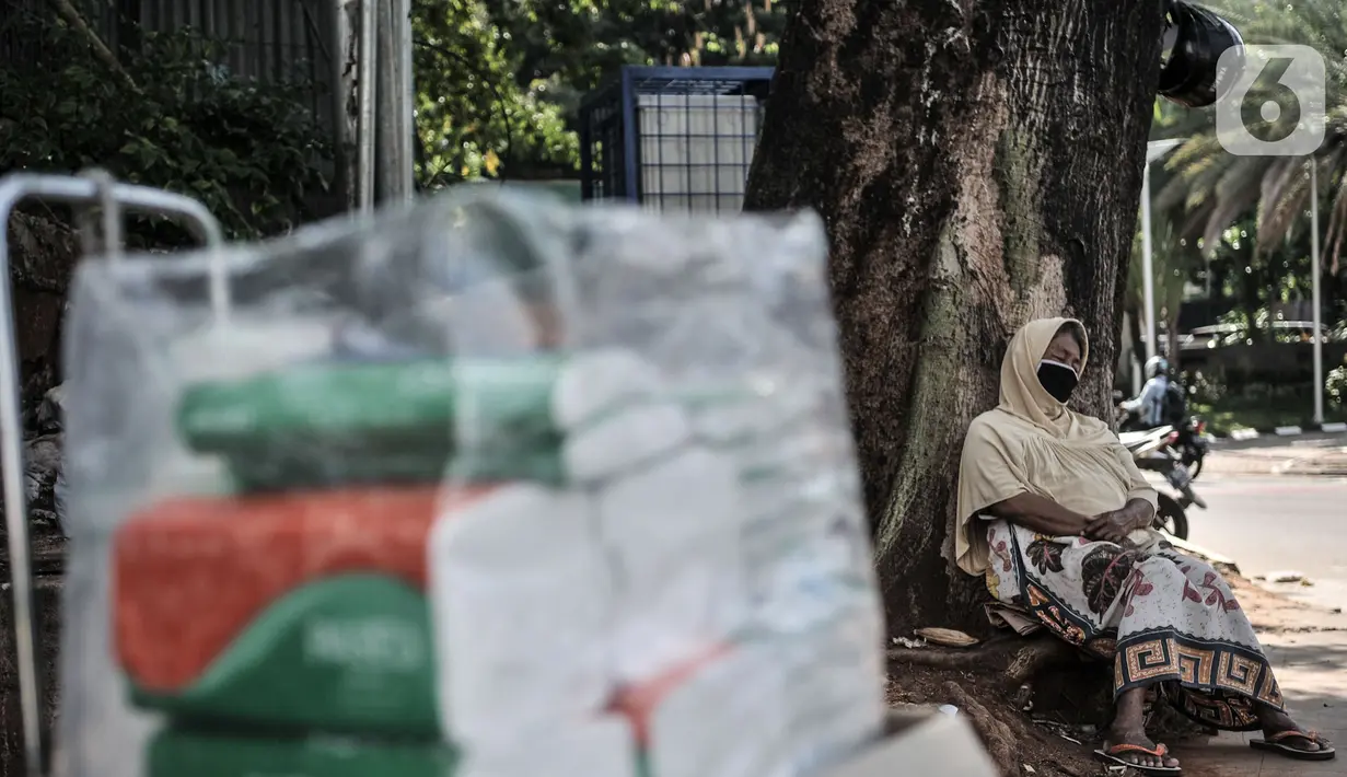 Pedagang asongan tertidur saat berjualan di kawasan Sudirman, Jakarta, Selasa (1/9/2020). Dalam aturan tersebut tertulis PSBB Transisi di Jakarta diperpanjang hingga 10 September 2020. (merdeka.com/Iqbal S. Nugroho)
