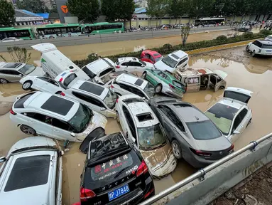 Mobil-mobil terendam banjir setelah hujan lebat melanda kota Zhengzhou di provinsi Henan tengah China (21/7/2021). Luapan sungai menggenangi jalan-jalan dan membuat kendaraan terbawa arus setelah curah hujan 200 mm turun dalam satu jam. (AFP/STR)