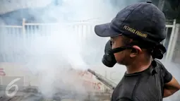 Petugas melakukan pengasapan (fogging) di kelurahan Menteng, Jakarta, Senin (8/2). Pengasapan oleh petugas puskesmas setempat itu dilakukan untuk mencegah wabah penyakit demam berdarah yang kerap muncul pada peralihan musim. (Liputan6.com/Faizal Fanani)