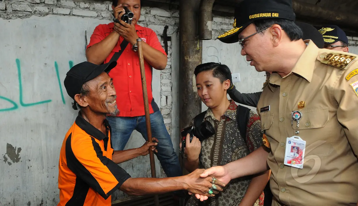 Gubernur DKI Jakarta Basuki T Purnama bersalaman dengan warga saat menuju pasar Tanah Abang, Jakarta, Rabu (15/4). Ahok berjalan kaki dari Stasiun Tanah Abang menuju Pasar Blok G untuk mengecek kondisi trotoar jalan. (Liputan6.com/Herman Zakharia)