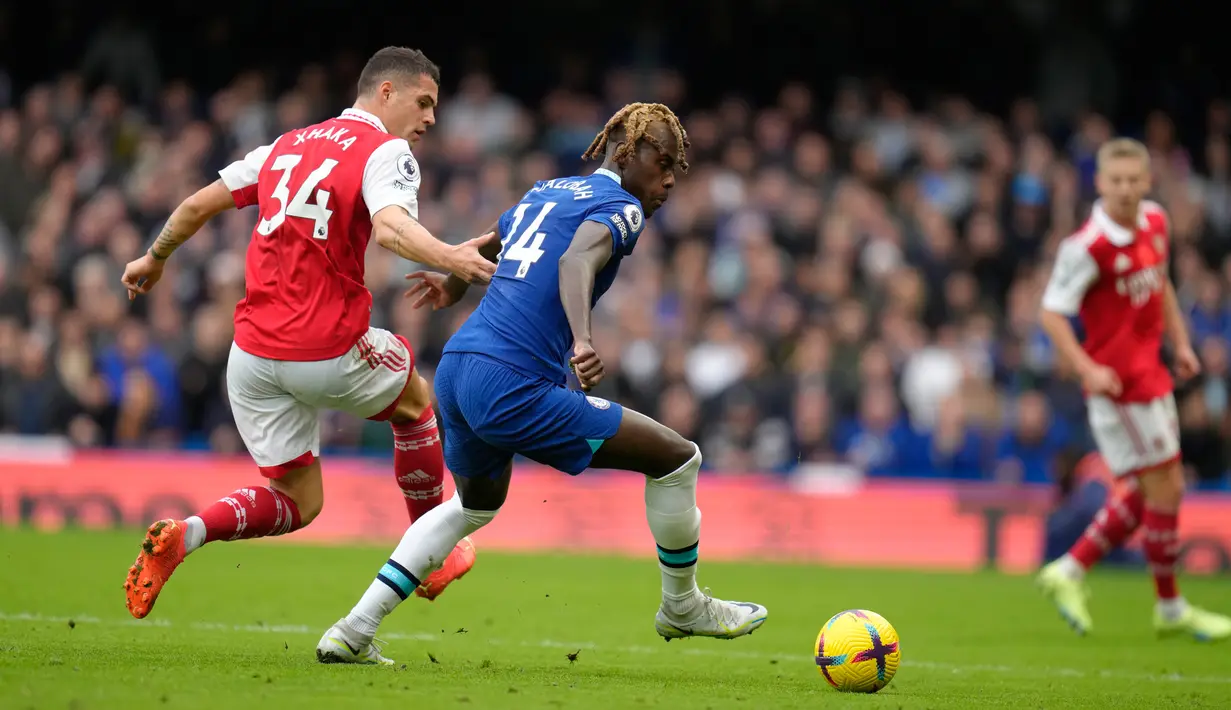 Pemain Chelsea Trevoh Chalobah (tengah) berebut bola dengan pemain Arsenal Granit Xhaka pada pertandingan sepak bola Liga Inggris di Stadion Stamford Bridge, London, Inggris, 6 November 2022. Arsenal kembali memuncaki klasemen Liga Inggris usai mengalahkan Chelsea dengan skor 1-0. (AP Photo/Kirsty Wigglesworth)