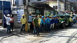 Pekerja konstruksi menyelamatkan diri dengan keluar bangunan setelah gempa berkekuatan magnitudo 7,1 terasa di Manila, Filipina, Rabu (27/7/2022). Berdasarkan informasi dari USGS Earthquakes, gempa mengguncang pada pukul 07.43 waktu setempat. (JAM STA ROSA/AFP)