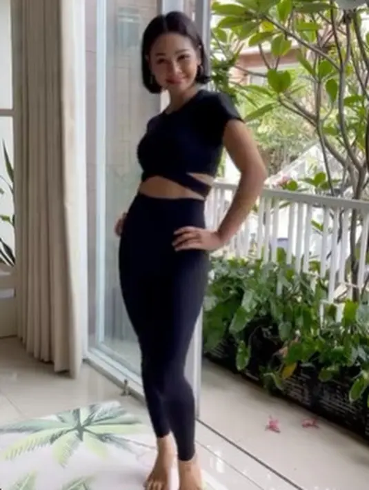 Andien berbagi rutinitas olahraganya yang bikin perut rata. Ia mengenakan atasan dengan strap di bagian pinggang yang dipadukan dengan legging hitam.  (instagram/andienaisyah)