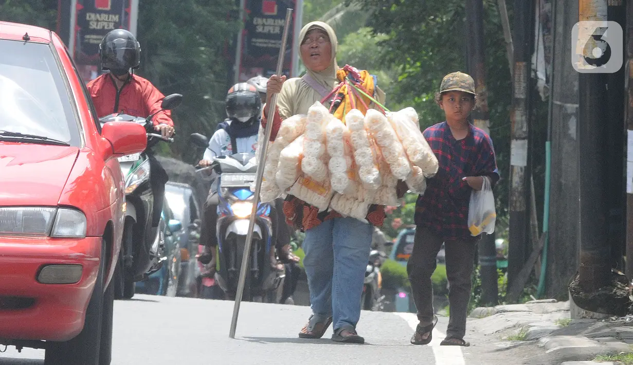 <p>Penyandang tunanetra Ibu Adel (48) berjalan bersama anak bungsunya menyusuri jalan raya Ciputat, Tangerang Selatan, Selasa (26/04/20222). Warga Pondok Cabe 3 ini setiap harinya menyusuri jalan hingga sekitar 10 km menjajakan kerupuk Bangka yang dijualnya Rp 25 ribu/bungkus. Sudah beberapa bulan terakhir ini ia mengaku pendapatannya merosot drastis hanya sekitar Rp 50 ribu/ hari yang digunakan untuk mencukupi kebutuhan sehari-hari. (merdeka.com/Arie Basuki)</p>