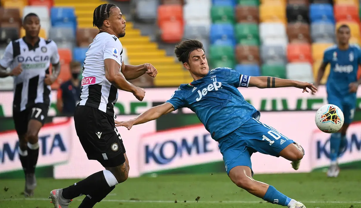 Penyerang Juventus,  Paulo Dybala menendang bola dari kawalan bek Udinese, William Troost-Ekong pada pertandingan lanjutan Liga Serie A Italia di Stadion Dacia Arena di Udine (23/7/2020). Udinese menang 2-1 atas Juventus. (AFP Photo/Marco Bertorello)