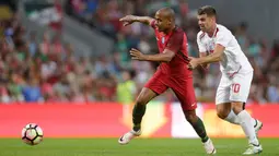 Gelandang Portugal, Joao Mario, melewati pemain Gibraltar, Liam Walker. Juara Eropa 2016 itu menguasai jalannya laga dengan penguasaan bola sebesar 86 persen. (Reuters/Miguel Vidal)