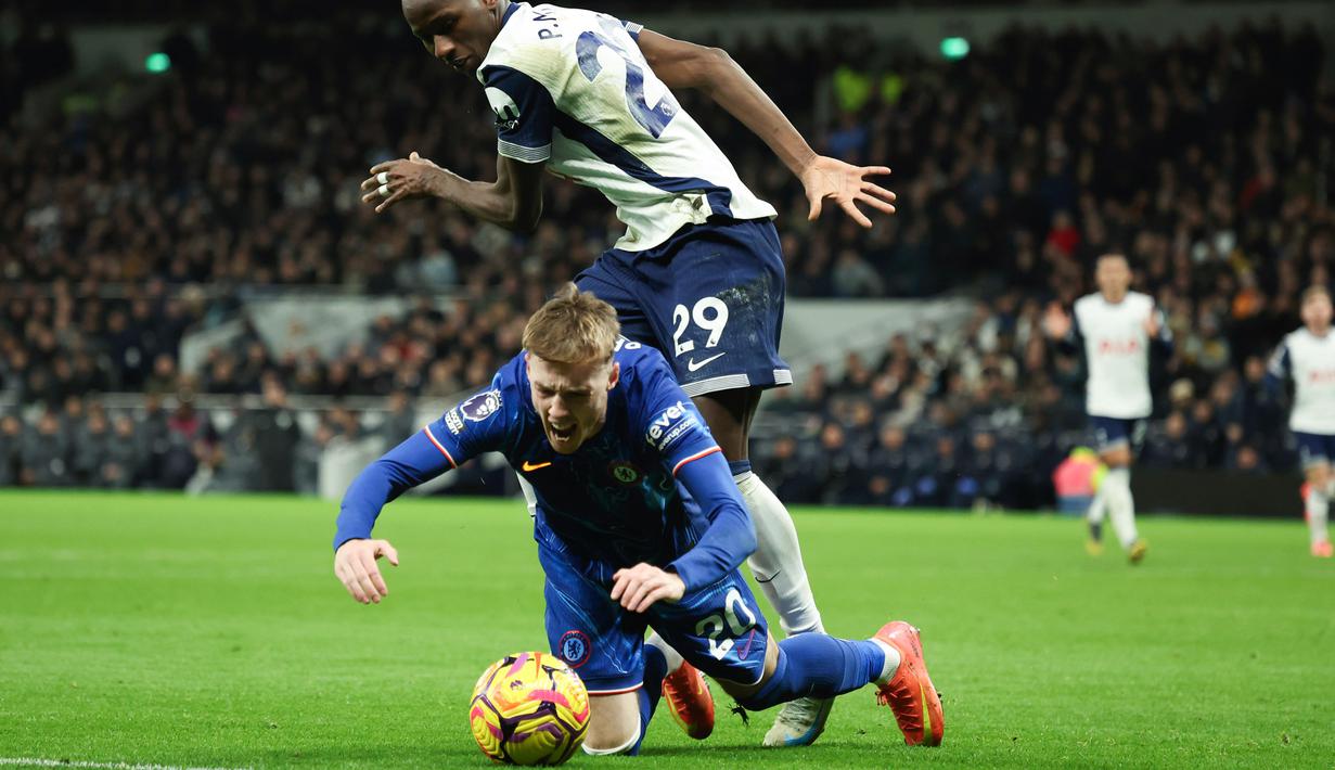 Pemain Chelsea, Cole Palmer, dilanggar pemain Tottenham Hotspur, Pape Matar Sarr, pada laga Liga Inggris di Stadion Tottenham Hotspur, Minggu (9/12/2024). (AP Photo/Ian Walton)
