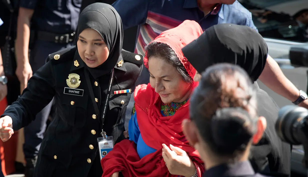 Istri mantan Perdana Menteri Malaysia Najib Razak, Rosmah Mansor dikawal petugas saat memenuhi panggilan Komisi Antikorupsi Malaysia (MACC) di Putrajaya, Selasa (6/5). Rosmah tampak tenang turun dari mobil dan berjalan ke kantor MACC. (AP/Vincent Thian)
