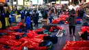Orang-orang bersiap-siap untuk tidur di area terbuka dalam acara World's Big Sleep Out di Times Square, New York, 7 Desember 2019. Aksi di beberapa kota besar dunia ini sebagai bagian dari upaya penggalangan dana untuk membantu para tunawisma di banyak negara. (Eduardo Munoz Alvarez/AFP)
