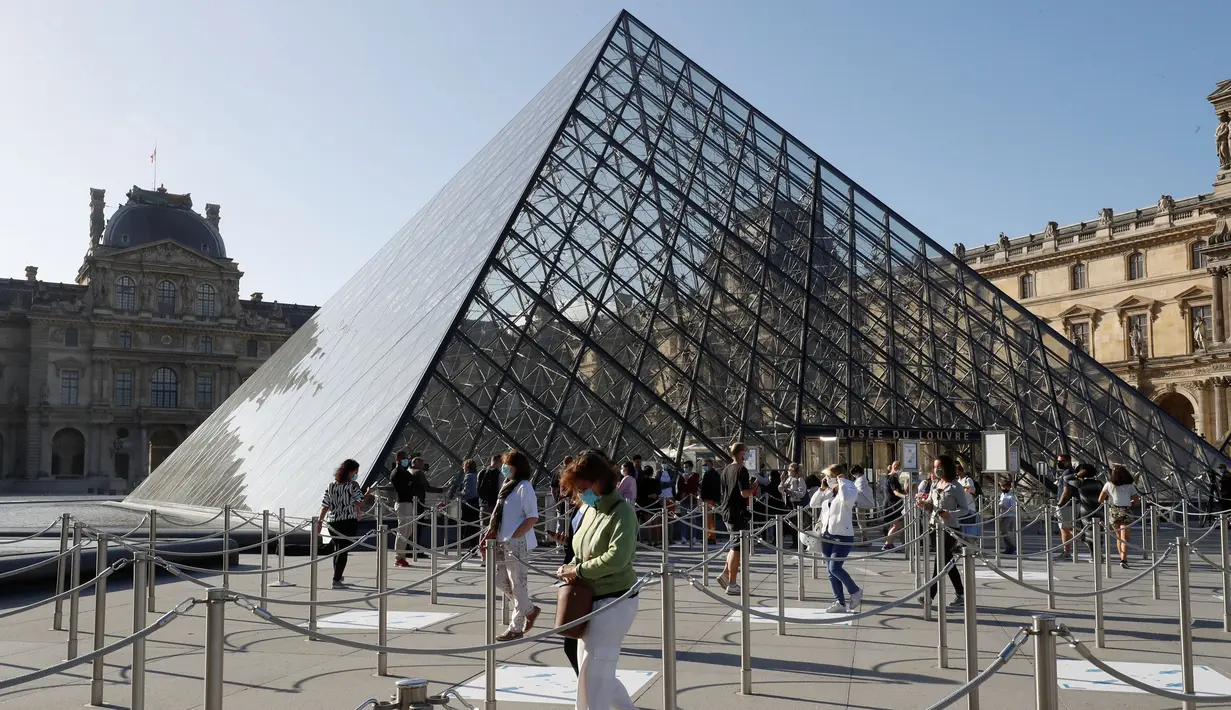 <p>Pengunjung tiba di piramida Louvre yang dirancang arsitek China Ieoh Ming Pei, pintu masuk ke Museum Louvre di Paris (6/7/2020). Presiden dan direktur Louvre Jean-Luc Martinez mengatakan, krisis coronavirus telah menyebabkan "lebih dari 40 juta euro dalam kerugian di Louvre. (AFP/Francois Guillot)</p>