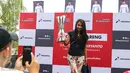 Seorang pengunjung berpose dengan piala F1 di arena acara Nonton Bareng F1 GP Australia 2016 Pertamina di Mall Bintaro Xchange, Tangerang Selatan, Minggu (20/3). Acara tersebut terbuka untuk umum, termasuk fans Rio Haryanto. (Liputan6.com/Fery Pradolo)