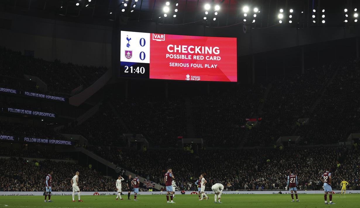 Papan skor menunjukkan tinjauan VAR atas pelanggaran yang berpotensi mendapatkan kartu merah pada laga putaran ketiga Piala FA 2023/2024 antara Tottenham Hotspur menghadapi Burnley di Tottenham Hotspur Stadium, London, Sabtu (6/1/2024) dini hari WIB. (AP Photo/Ian Walton)