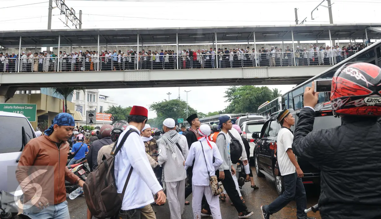 Peserta aksi 2 Desember memadati jembatan penyeberangan orang (JPO) di kawasan Pasar Baru, Jakarta, Jumat (2/12). Aksi berjalan lancar dan damai. (Liputan6.com/Helmi Afandi)