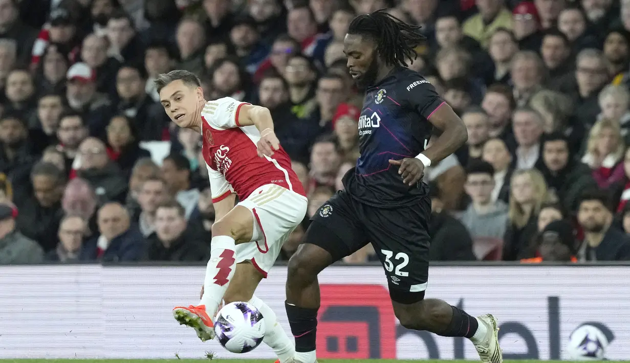 Gelandang Arsenal, Leandro Trossard (kiri) berebut bola dengan gelandang Luton Town, Fred Onyedinma pada laga pekan ke-31 Premier League 2023/2024 di Emirates Stadium, London, Rabu (3/4/2024) malam. (AP Photo/Frank Augstein)