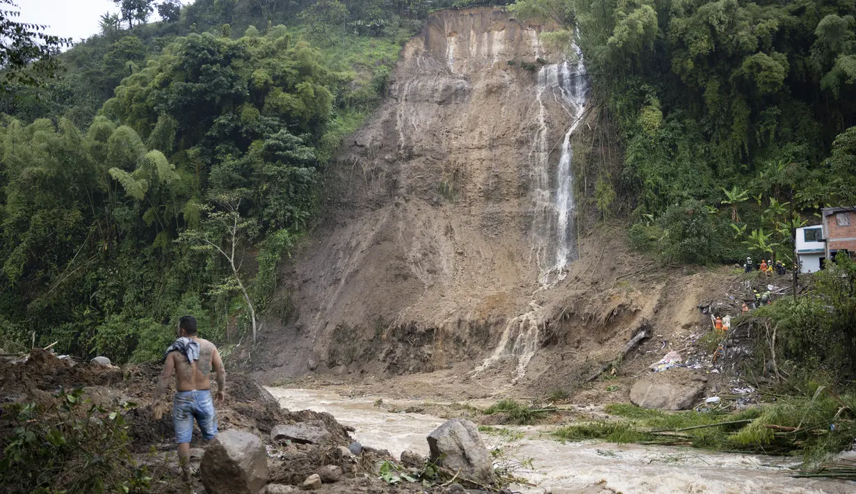 Seorang pria menghadapi lereng bukit yang diguyur hujan yang runtuh menimpa rumah-rumah penduduk di Pereira, Kolombia, Selasa (8/2/2022). Hujan deras memicu tanah longsor menewaskan sedikitnya 14 orang dan melukai 35 lainnya. (AP Photo/Andres Otalvaro)