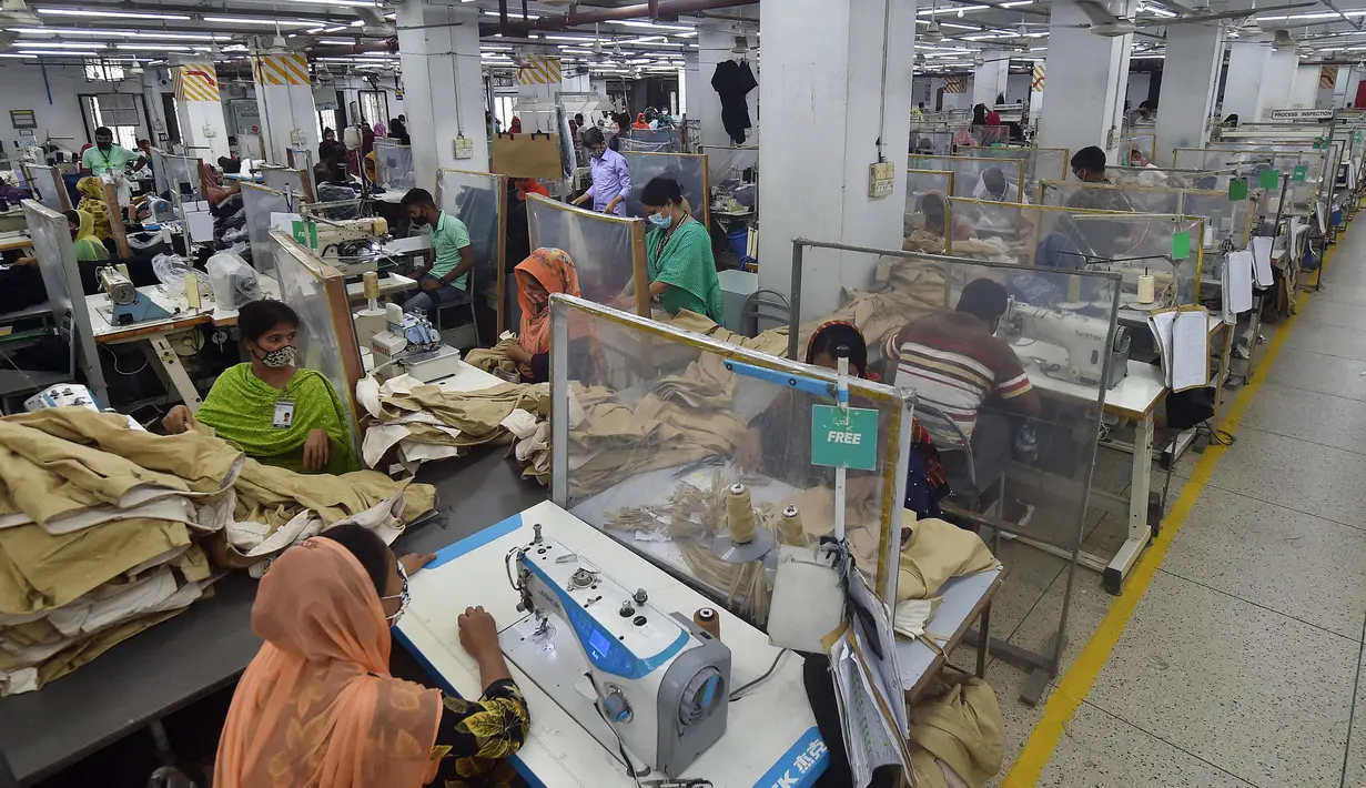 Para buruh bekerja pada stasiun mereka yang dipisahkan oleh sekat sebagai tindakan pencegahan terhadap penularan virus corona COVID-19 di pabrik garmen Civil Engineers Limited, Dhaka, Bangladesh, 17 Agustus 2021. (Munir UZZAMAN/AFP)