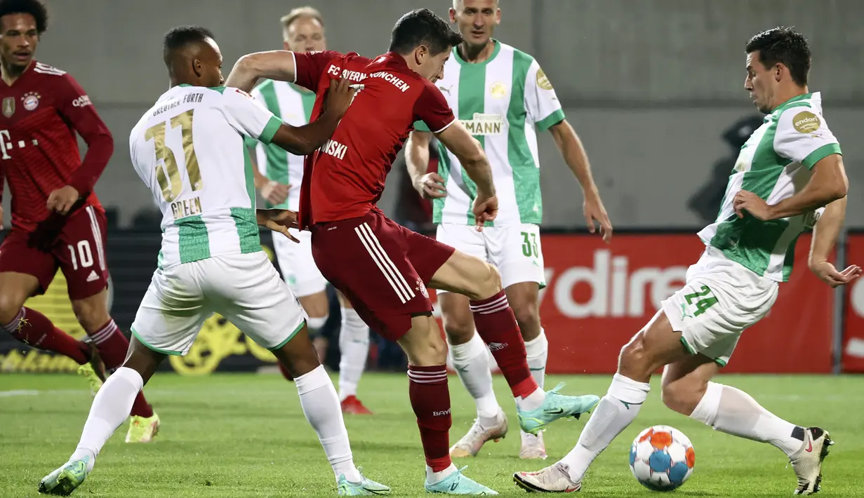 Penyerang Bayern Munchen Robert Lewandowski berusaha menguasai bola dibayangi pemain Greuther Fuerth pada pekan keenam Liga Jerman 2021/2022 di Trolli Arena, Sabtu (25/9/2021) dini hari WIB. Die Roten –julukan Bayern Munchen – menang 3-1 atas tim promosi Greuther Furth. (Daniel Karmann/dpa via AP)