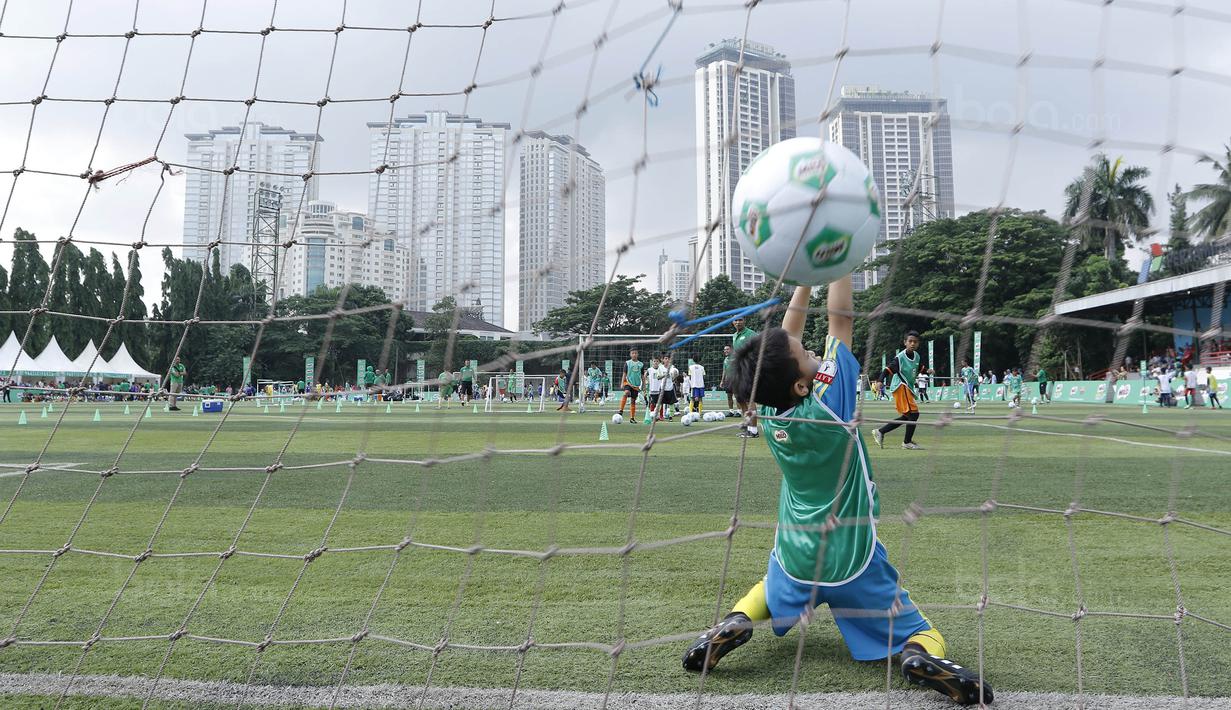 Seorang anak berusaha menangkap bola saat mengikuti MILO Football Clinic Day di Lapangan Simprug, Jakarta, Sabtu (16/12/2017). Sebanyak 500 anak mendapatkan pelatihan dasar teknik sepak bola dari pelatih berpengalaman. (Bola.com/M Iqbal Ichsan)