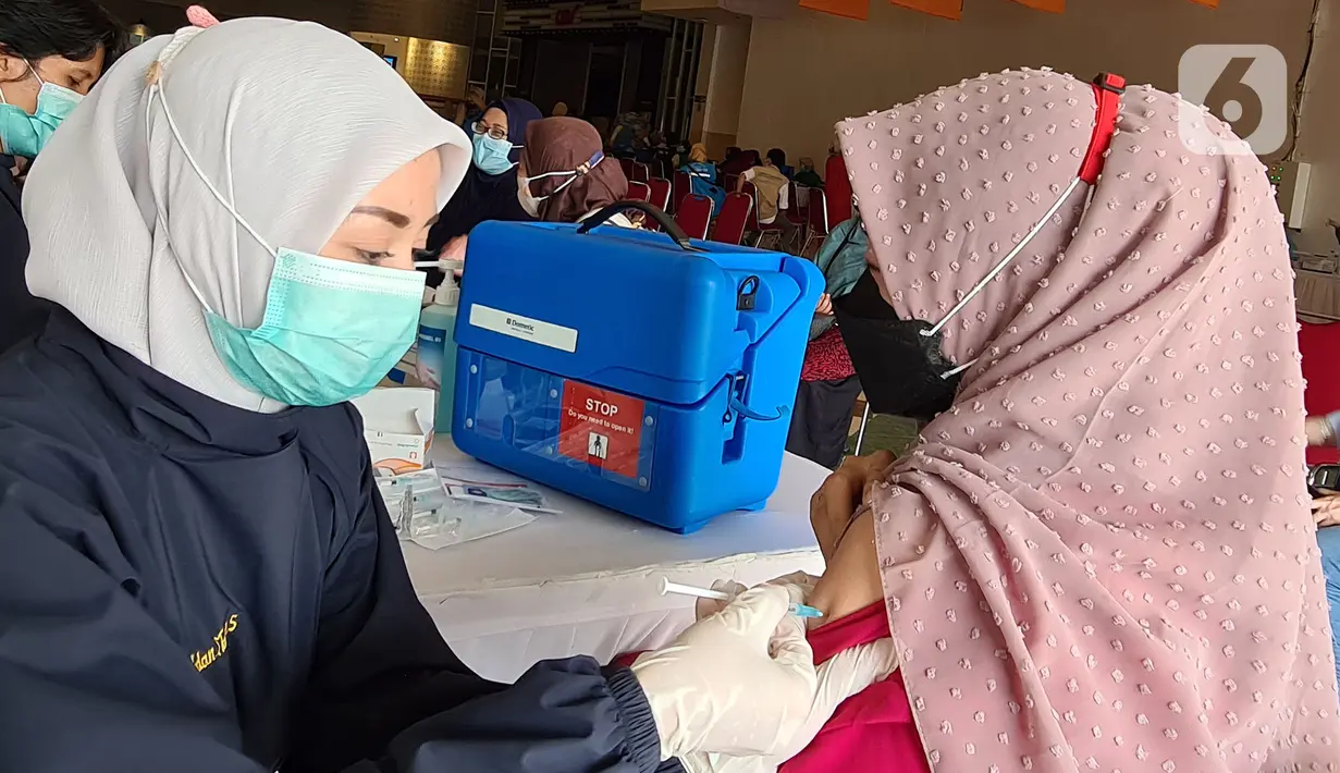 Paramedis melakukan penyuntikan vaksin Covid-19 kepada guru di Teraskota Mall. Tangerang Selatan, Banten, Rabu (28/04/2021). Vaksinasi dalam rangka persiapan kegiatan belajar tatap muka secara terbatas di wilayah Tangsel pada Juli mendatang. (merdeka.com/Arie Basuki)