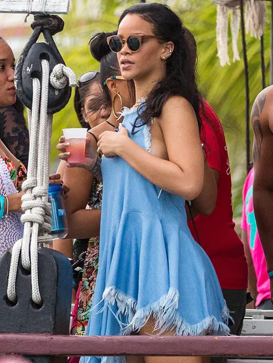 Penyanyi Rihanna berada di atas perahu saat berlibur di sebuah pantai di Barbados pada 26 Desember 2015 lalu. Mantan kekasih Chris Brown itu terlihat seksi dalam balutan dress biru yang cocok dengan suasana pantai. (www.thesun.co.uk)