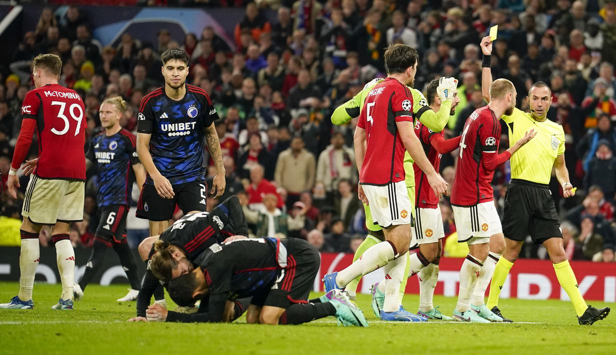 Wasit Marco Guida (kiri) mengeluarkan kartu merah kepada gelandang Manchester United, Scott McTominay dan memberi hadiah penalti kepada FC Copenhagen pada laga matchday ketiga Grup A Liga Champions 2023/2024 di Old Trafford Stadium, Rabu (25/10/2023) dini hari WIB. (AP Photo/Dave Thompson)