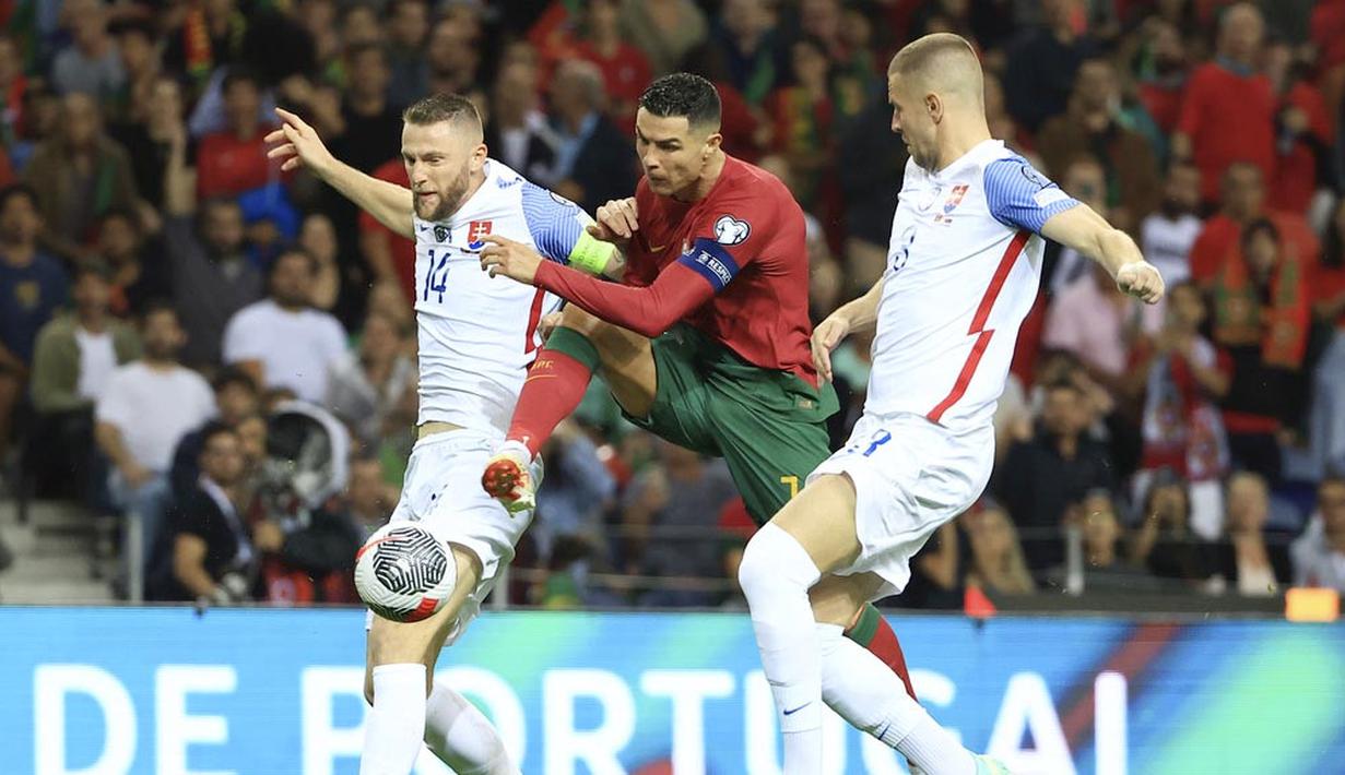 Pemain Portugal, Cristiano Ronaldo, berusaha melewati pemain Slovakia, Milan Skriniar dan Denis Vavro, pada laga Kualifikasi EURO 2024 di Stadion Dragao, Sabtu (14/10/2023). Portugal menang dengan skor 3-2. (AP Photo/Luis Vieira)