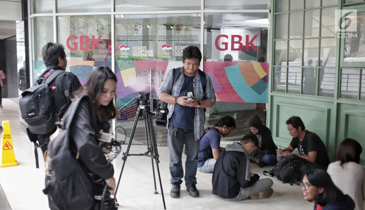Awak media menunggu di luar kantor PSSI saat penggeledahan oleh Satgas Antimafia Bola Polri di FX Office Tower, Jakarta, Rabu (30/1). Penggeledahan itu pengembangan kasus 10 tersangka kasus pengaturan skor sepak bola Indonesia (Liputan6.com/Faizal Fanani)