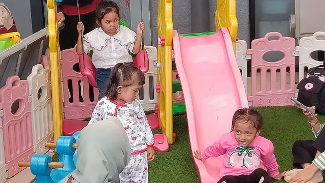 Penumpang yang akan mudik menunggu kereta dengan menemani anak bermain di Stasiun Pasar Senen, Minggu (7/4/2024).