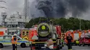 Kendaraan darurat pemadam kebakaran, layanan penyelamatan dan polisi terlihat tidak jauh dari akses jalan ke Chempark di mana asap membubung di Leverkusen, Jerman (21/7/2021). Kepolisian masih menyelidiki kasus ledakan dan belum diketahui penyebab terjadinya ledakan itu. (AP Photo/Oliver Berg)