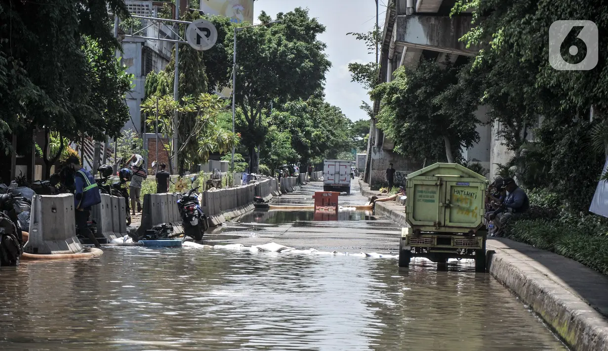 Petugas menggunakan pompa saat menyedot banjir yang menggenangi Jalan RE Martadinata, Ancol, Jakarta, Selasa (9/11/2021). Banjir disebabkan oleh meluapnya Kali Ciliwung Gunung Sahari dan ditambah fenomena air pasang laut yang terus terjadi. (merdeka.com/Iqbal S. Nugroho)