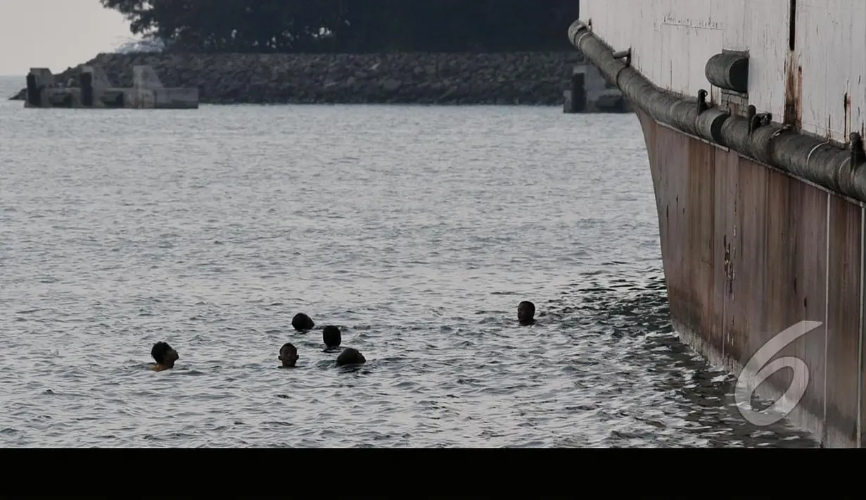 Para bocah pelabuhan ini menunggu para pemudik melempar koin ke laut. Aksi rebutan koin menjadi hiburan bagi pemudik, Banten, Jumat (25/07/2014) (Liputan6.com/JohanTallo)