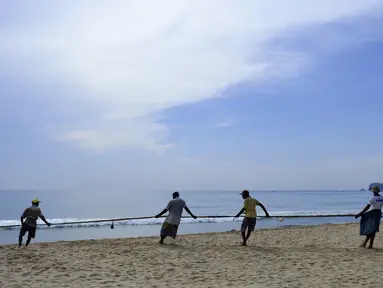 Para nelayan Sri Lanka menarik jaring ikan di pantai di Trincomalee (5/5). Trincomalee adalah kota pelabuhan di bagian timur Sri Lanka. (AFP Photo/Ishara S Kodikara)