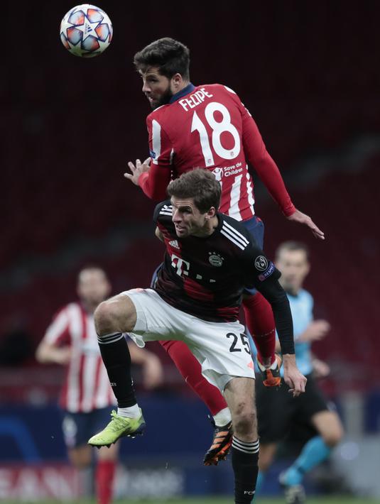 Bek Atletico Madrid, Felipe (atas) menyundul bola saat berebut dengan penyerang Bayern Munchen, Mueller pada matchday kelima Grup A Liga Champions di Stadion Wanda Metropolitano, Madrid, Rabu (2/12/2020) dini hari WIB. Atletico Madrid vs Bayern Munchen berakhir imbang 1-1. (AP Photo/Bernat Armangue)