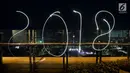Coretan lampu tahun 2018 menghiasi malam pergantian tahun baru di kawasan silang Moumen Nasional (Monas), Jakarta, Senin (1/1/2018). (Liputan6.com/Johan Tallo)