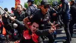 Polisi Turki menangkap seorang pemrotes yang mencoba menentang larangan dan berbaris di Lapangan Taksim saat peringatan Hari Buruh di Istanbul, Turki (1/5). (AFP/Yasin Akgul)