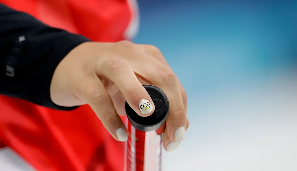 Atlet curling Kanada, Rachel Homan memperlihatkan kuku cantiknya yang dicat warna putih saat bertanding pada Olimpiade Musim Dingin Pyeongchang 2018, Jumat (16/2). Salah satu kukunya pun ada yang dihias lambang Olimpiade Pyeongchang (AP/Natacha Pisarenko)