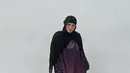 Selanjutnya, Sivia mengenakan pashmina hitam panjang polos dipadukan abaya warna gradasi merah hitam dengan corak serta mengenakan sneakers Nike hitam putih.  [@siviazizah]