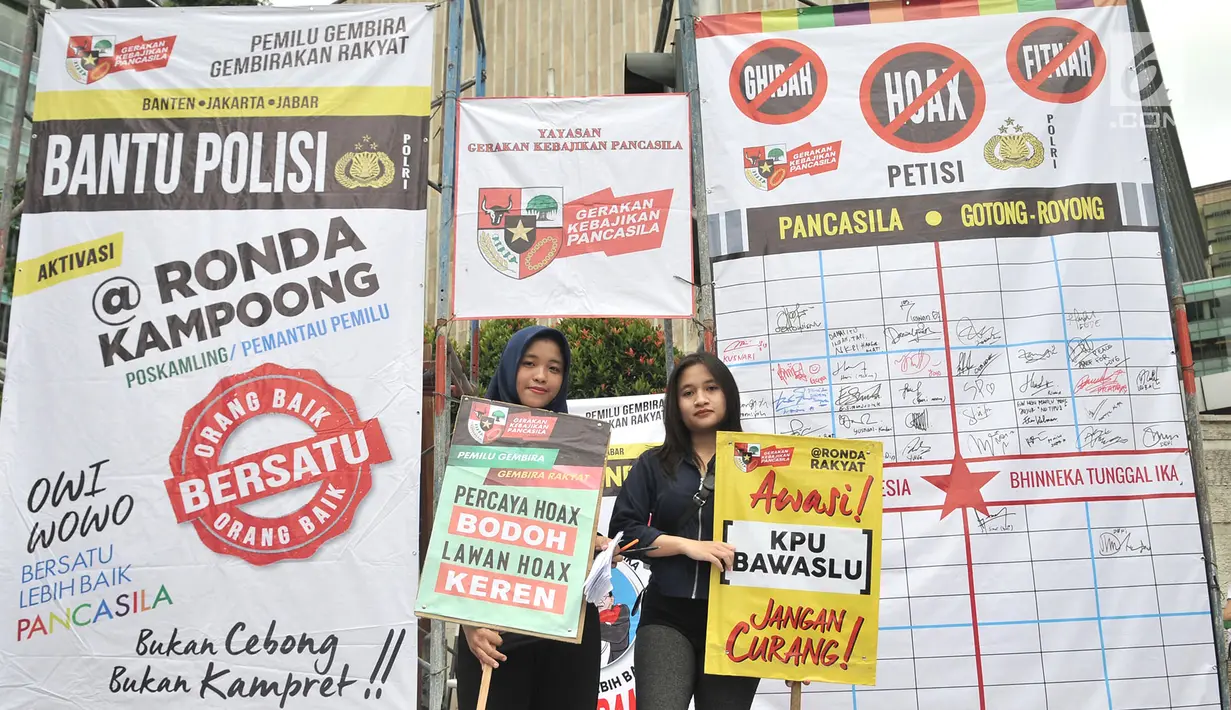 Relawan membawa poster pada saat kampanye Pemilu Damai pada CFD di kawasan Bundaran HI, Jakarta, Minggu (17/3). Kampanye yang digelar Gerakan Kebijakan Pancasila mengajak masyarakat untuk menjaga pemilu dari hoax. (merdeka.com/Iqbal S Nugroho)