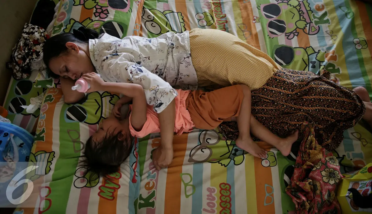 Anak Tertidur ditemani pengasuh di rumah singgah Yayasan Kasih Anak Kanker Indonesia, Jakarta, Senin (15/2). Setiap tahun diperkirakan 250.000 anak terdiagnosis kanker dan 90.000 diantaranya meninggal. (Liputan6.com/Faizal Fanani)