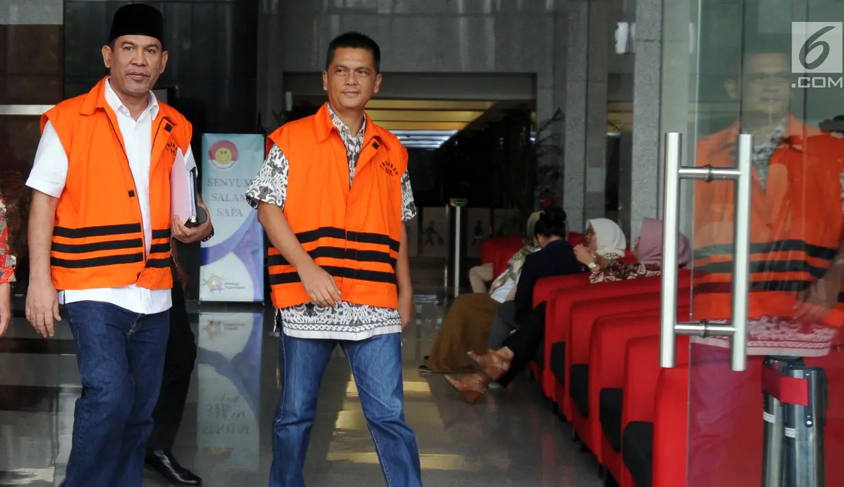 Dua tersangka, Bupati Hulu Sungai Tengah Abdul Latif (kiri) serta Direktur PT Indo Jaya dan PT Sarana Bangun Nusantara Hasmun Hamzah (kanan) berjalan keluar usai menjalani pemeriksaan di gedung KPK, Jakarta (23/3). (Merdeka.com/Dwi Narwoko)