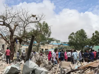 Warga Somalia berkumpul di lokasi ledakan bom mobil di luar kantor pemerintah lokal di Mogadishu, Somalia, (10/9). Menurut polisi Somalia dan pekerja penyelamat, enam orang tewas dan 16 luka-luka akibat ledakan tersebut. (AFP Photo/Abdi Haji Hussein)